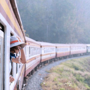Woman looks out from window traveling by train